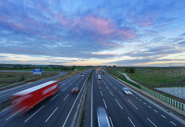 Motorway with cars and lorries speeding along past a junction